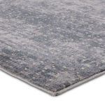 Close-up corner view showing textured high-low pile and tightly finished edge in blue and cream dots