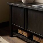 Styled view of Dalton Media Console on hardwood floor with woven baskets on slatted shelf