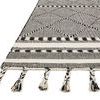 Angled view showing knotted fringe detail and patterned borders on Sawyer Black Rug