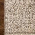 Close-up of the rug’s beige and bone floral pattern with fringed edge on hardwood floor