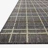 Low angled side view showing flat weave texture and edge of Rainier charcoal plaid rug