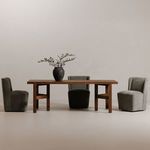 Dining set with three Cormac rolling chairs in dark gray surrounding a wooden table with vase centerpiece