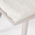 Close-up featuring soft texture and color contrast of sheepskin cushion on seat edge