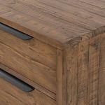 Close-up of a bottom corner leg in black iron with tapered profile and adjustable foot pad