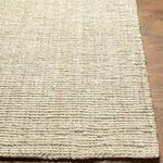 Angled close-up of Calla Butter Handmade Rug showing slightly uneven handwoven edge on wood floor