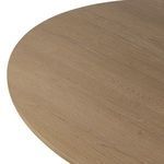 Close-up of rounded edge of round tabletop with visible oak grain.