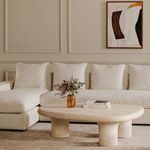 Thomas sectional styled in a neutral living room with a round beige coffee table and artwork on wall
