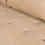 Detail of housing plinth parawood base beneath tan leather upholstery