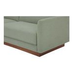 Close-up of sofa corner with textured sage green fabric and wooden base detail