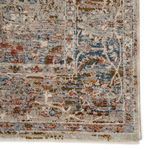 Detailed close-up of rug corner with textured weave and muted color palette of gray, blue, and rust hues