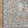 Top close-up showing the rug's detailed patterned border on hardwood floor