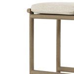 Close side view focusing on teak bar stool leg and frame texture beneath cushion