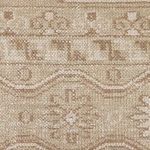 Detailed macro of floral and geometric pattern in beige and taupe tones on rug surface