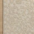 Rug positioned on wood floor highlighting the border and color gradation of the hand-tufted wool and cotton
