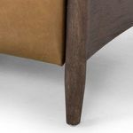 Close-up of olive green leather upholstery covering recliner backrest and armrest