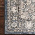 Close-up of Teagan Denim / Mist Rug on dark hardwood floor focusing on border and texture