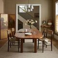 Bradley rug styled under dining table with wooden chairs in a brown-toned room