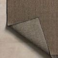 Corner of Providence rug folded to reveal the reverse side with woven pattern and neutral tones
