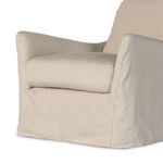Side angle close detail highlighting floor-length slipcover drape and fabric weave