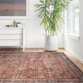 Layla Brick / Blue Rug placed on wood floor in bright room with plant and dresser
