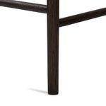 Detail of smoked oak tapered chair leg with wood grain and finish visible