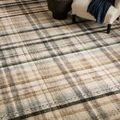 Close-up of rug next to cream armchair and black side table with décor items