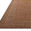Low-angle view showing the rug's profile and woven texture with subtle border detail