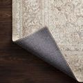Rug corner flipped up to reveal dark grey backing and tight, precise stitching along edges