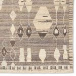 Detailed view of rug corner displaying diamond pattern and fringed edge finish