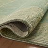 Rolled edge of rug revealing durable wool weave and backing texture