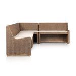 Close-up on corner joint where two rattan sectional pieces meet with cushions aligned