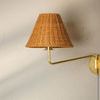 Issa sconce in aged brass finish mounted on beige wall showing side profile and warm light
