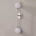 Two-light polished nickel wall sconce mounted on light gray wall showing shadows and side view