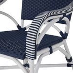 Close-up detail of navy woven resin wicker seat and white striped armrest wrapping
