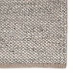 Close-up of rug’s dense, handwoven weave showcasing taupe and gray PET yarns with subtle texture