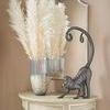 Fuller Architectural Arch Mirror shown hanging in a beige room above a small wooden console with vase and decorative monkey