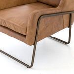 Close angle on chair’s cushioned seat corner and metal sled base framing