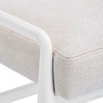 Close-up of beige textured fabric upholstery and white chair frame corner