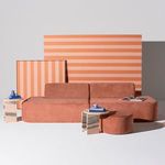 Styled Isla Sofa in room setting with terracotta-striped backdrops and small tables