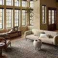 Heritage Lagoon Tobacco Rug styled in a bright living room beneath beige sofa and wicker chair