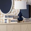 Tobago mirror showing white and navy blue decor including navy lamp and blue patterned boxes on beige cabinet