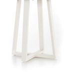 close crop of white metal base leg highlighting smooth finish and angular shape