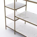 Detail close-up of three marble shelves supported by slim brass frame