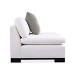 Side profile emphasizing cushion layers and pillow alignment on black wood block legs
