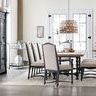 Dining room setting with six Ciao Bella chairs around rustic table on light patterned rug and large windows background