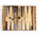 Open backgammon board with chips and dice placed on playing surface viewed from overhead on white background