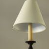 Detailed close-up of a single tapered linen shade and black metal candle socket with soft fabric texture