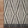 Close-up corner of the rug on wood flooring highlighting the thick woven edges and geometric pattern