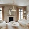 Radcliff pendant styled in a beige-toned living room centered above a wood coffee table with couches and decorative accents