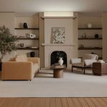 Cardero lounge chair styled in living room with beige walls, fireplace, built-in shelves, and wooden coffee table